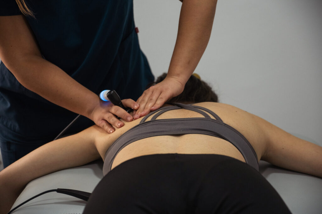 Fisioterapeuta tratando la espalda de una paciente en Clínica Restaura, Villalbilla